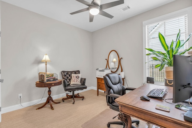 carpeted home office featuring visible vents, baseboards, and a ceiling fan