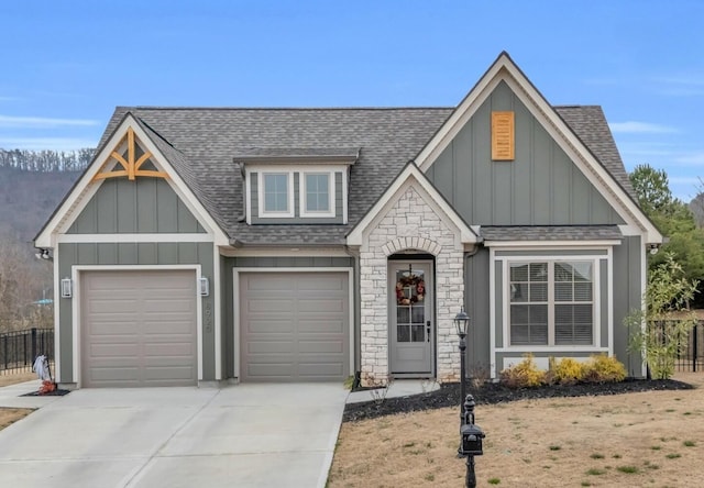 view of front of home with driveway, fence, roof with shingles, board and batten siding, and a garage