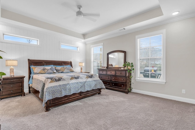 bedroom featuring a ceiling fan, baseboards, visible vents, a tray ceiling, and carpet flooring