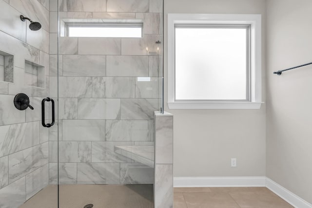 full bath with tile patterned floors, baseboards, a healthy amount of sunlight, and a shower stall