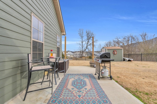 view of patio with a storage shed, an outbuilding, a fenced backyard, and a grill