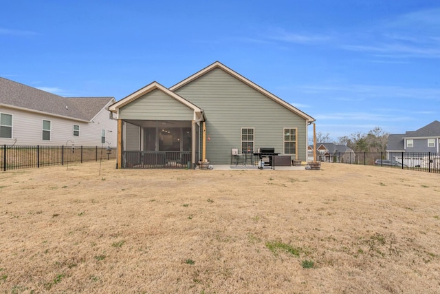 rear view of house featuring a patio area, a fenced backyard, and a sunroom