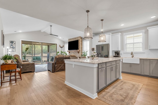 kitchen with gray cabinets, light wood-style floors, open floor plan, and a sink