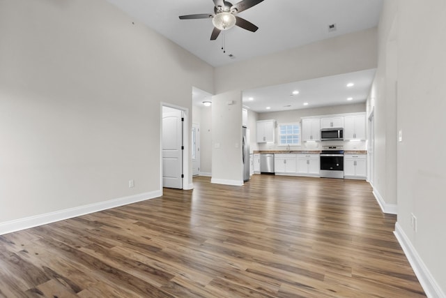 unfurnished living room with recessed lighting, baseboards, wood finished floors, and ceiling fan