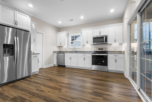 kitchen with a sink, stainless steel appliances, visible vents, and white cabinetry