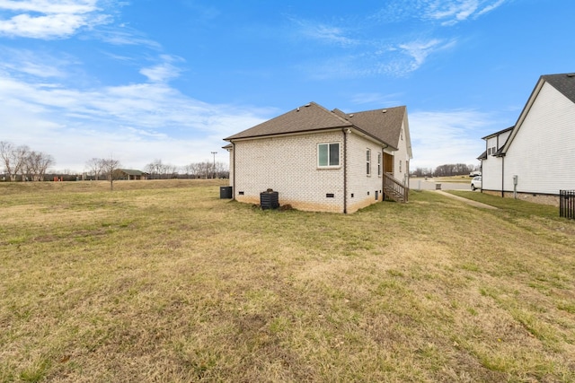 view of home's exterior with crawl space, a lawn, brick siding, and a shingled roof