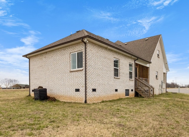 view of home's exterior featuring crawl space, brick siding, a yard, and roof with shingles