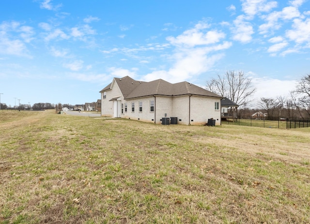 view of property exterior with cooling unit, a lawn, and fence