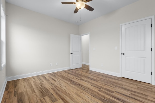 unfurnished bedroom featuring ceiling fan, baseboards, and wood finished floors