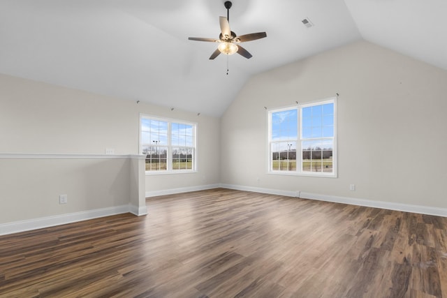 interior space featuring wood finished floors, visible vents, baseboards, ceiling fan, and vaulted ceiling