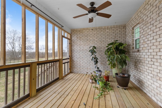 unfurnished sunroom with a ceiling fan and a healthy amount of sunlight