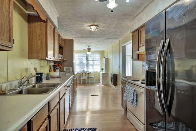 kitchen featuring refrigerator with ice dispenser, brown cabinetry, electric range, a ceiling fan, and a sink