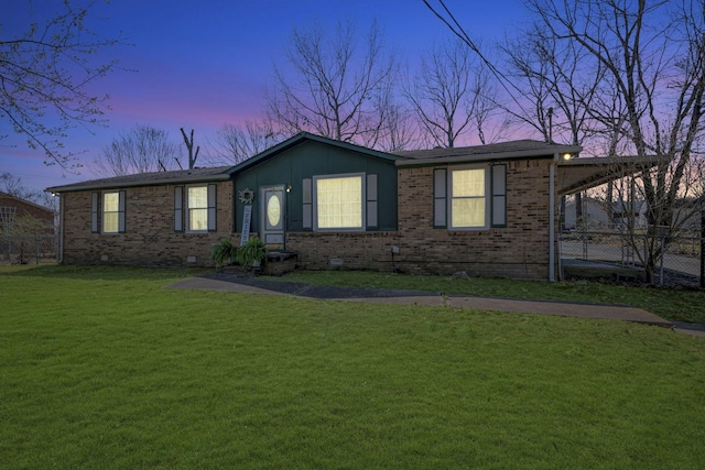 ranch-style home featuring a front yard, fence, and brick siding