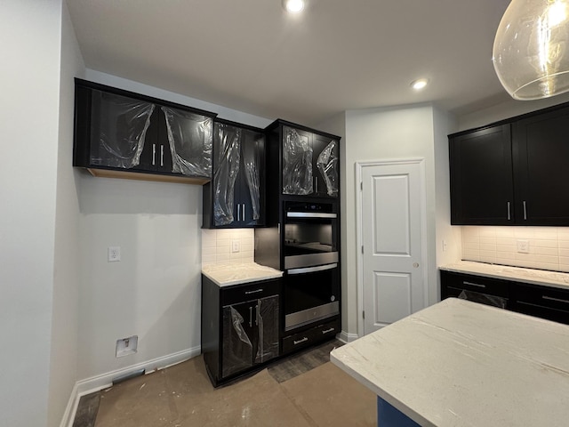 kitchen with tasteful backsplash, baseboards, double wall oven, recessed lighting, and dark cabinets