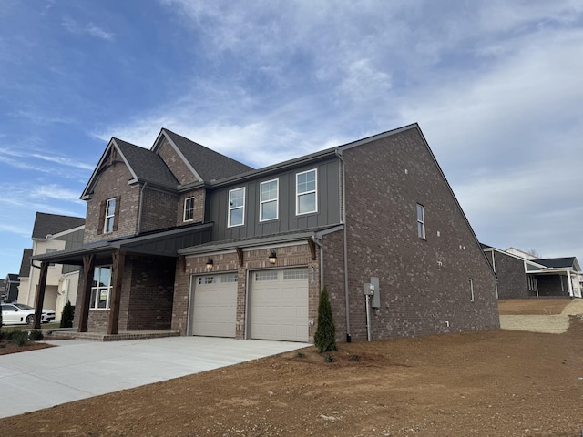 exterior space featuring board and batten siding, concrete driveway, a garage, and brick siding