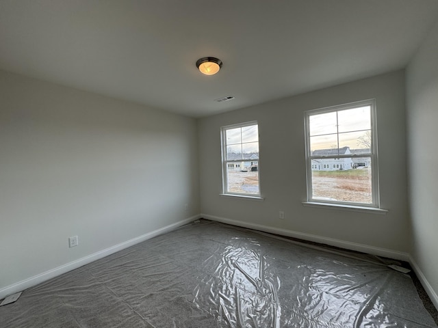 empty room featuring visible vents, baseboards, and a healthy amount of sunlight