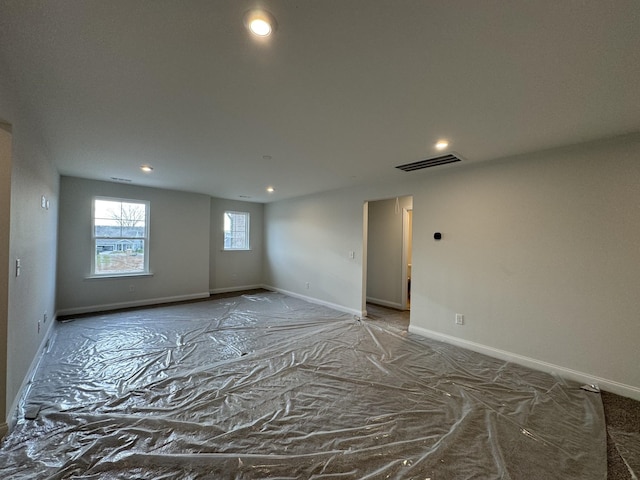 empty room featuring visible vents, recessed lighting, and baseboards