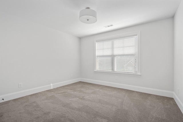 carpeted spare room with visible vents and baseboards