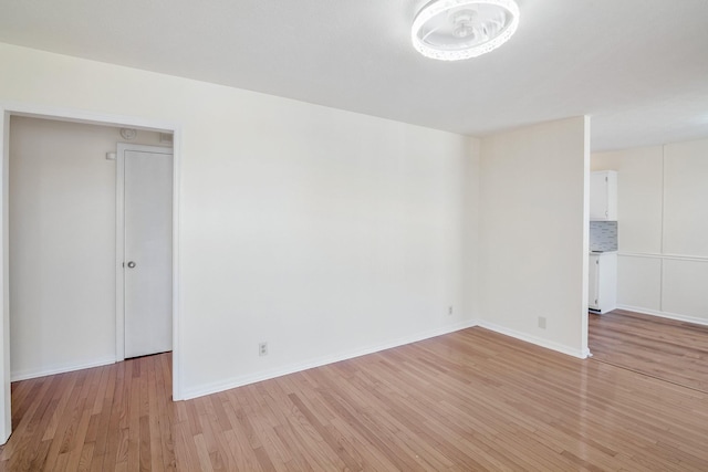 unfurnished room featuring baseboards and light wood finished floors