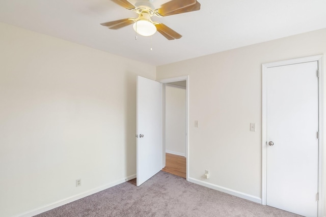 unfurnished bedroom featuring a ceiling fan, light colored carpet, and baseboards