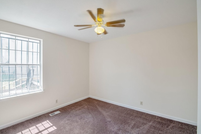 carpeted spare room featuring a ceiling fan, baseboards, and visible vents