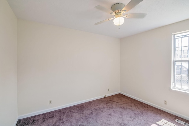 carpeted empty room featuring visible vents, baseboards, and a ceiling fan