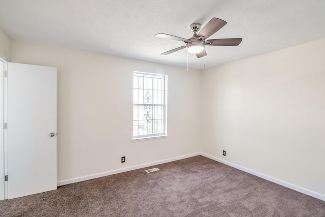 carpeted empty room featuring a ceiling fan, visible vents, and baseboards