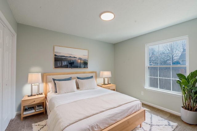 carpeted bedroom featuring multiple windows and baseboards