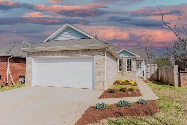 view of front of house featuring fence, driveway, roof with shingles, an attached garage, and brick siding