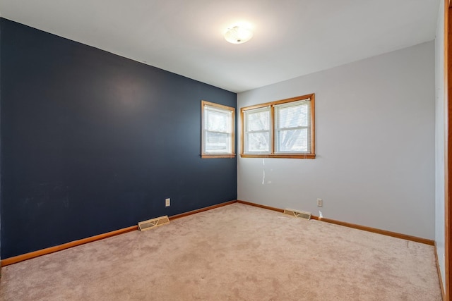 carpeted empty room with visible vents and baseboards