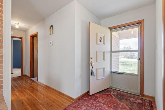 foyer with visible vents, baseboards, and wood finished floors