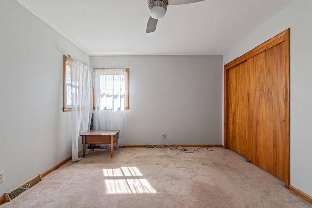 unfurnished bedroom with visible vents, light carpet, and baseboards