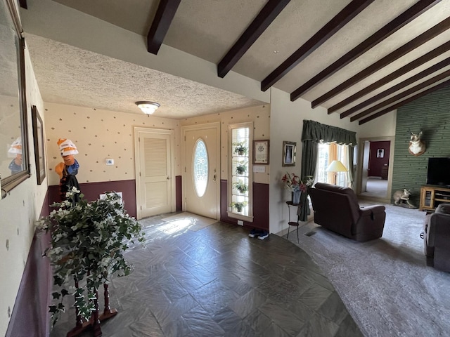 foyer featuring a wealth of natural light, beamed ceiling, a textured ceiling, and high vaulted ceiling