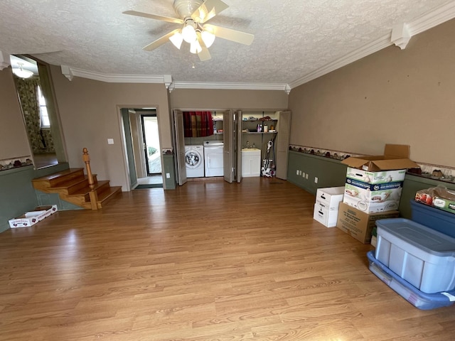 interior space with independent washer and dryer, light wood-style flooring, a textured ceiling, crown molding, and ceiling fan