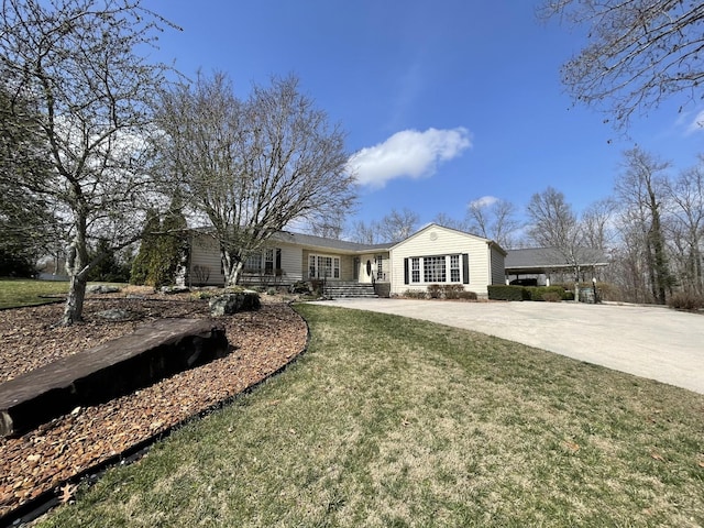 ranch-style home with a front lawn and concrete driveway