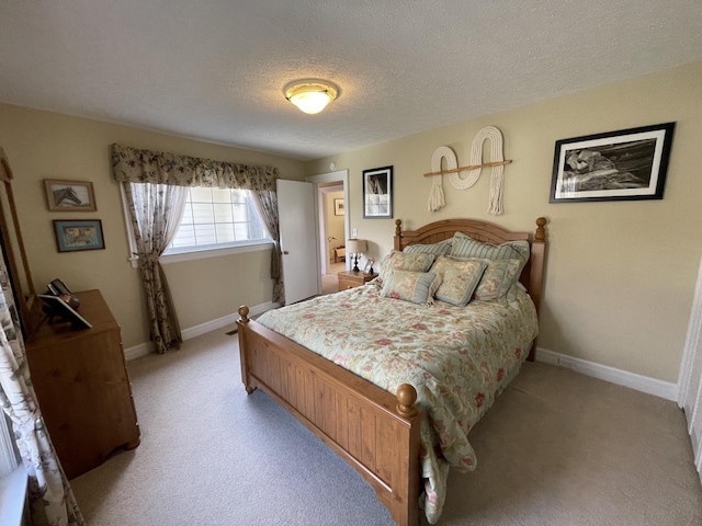 bedroom featuring light colored carpet, baseboards, and a textured ceiling