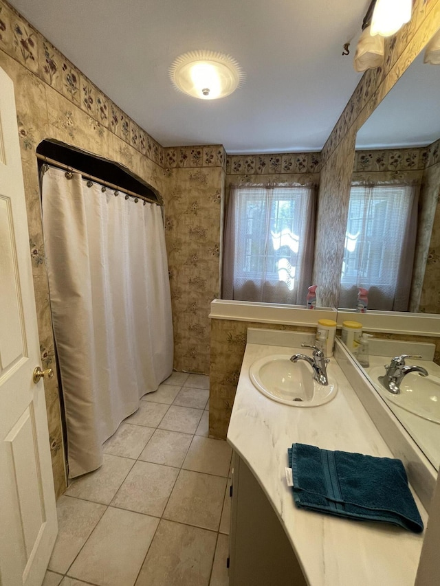 bathroom with a shower with shower curtain, wallpapered walls, vanity, and tile patterned flooring