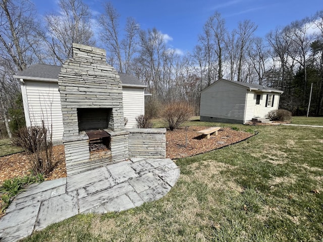 view of yard featuring a patio area and an outdoor stone fireplace