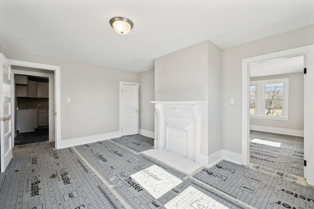 unfurnished living room with tile patterned floors and baseboards