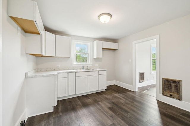 57 Young Branch Rd, Dixon Springs, TN 37057 - kitchen featuring dark wood-style flooring, baseboards, white cabinetry, heating unit, and light countertops