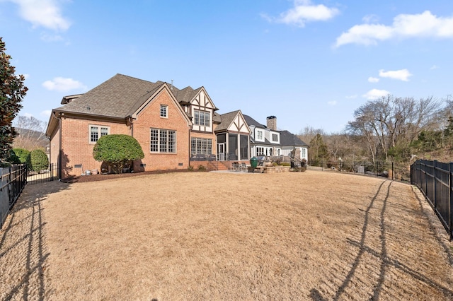 rear view of house featuring crawl space, a fenced backyard, brick siding, and a shingled roof