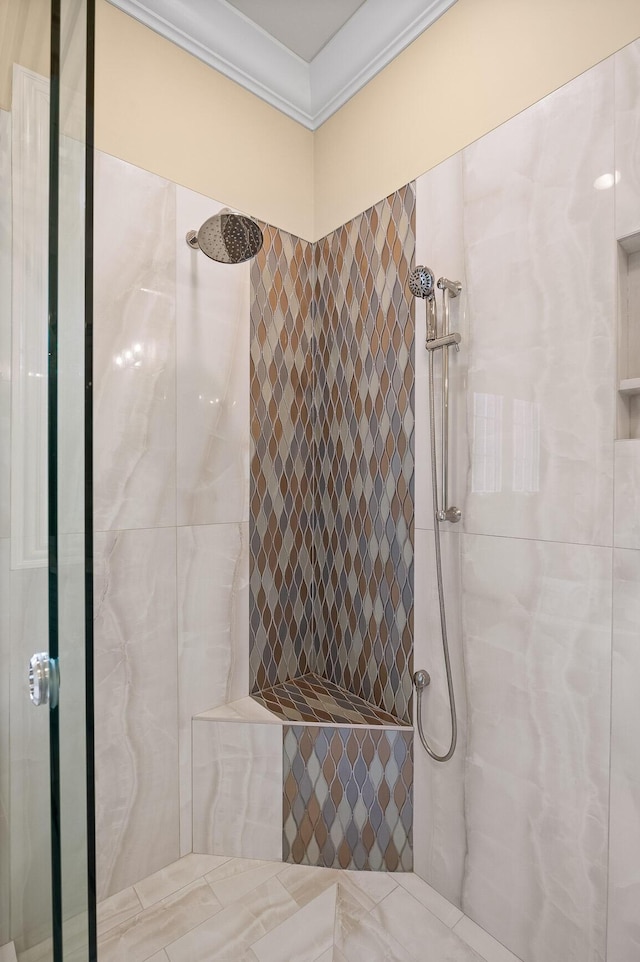 full bathroom with a tile shower and crown molding