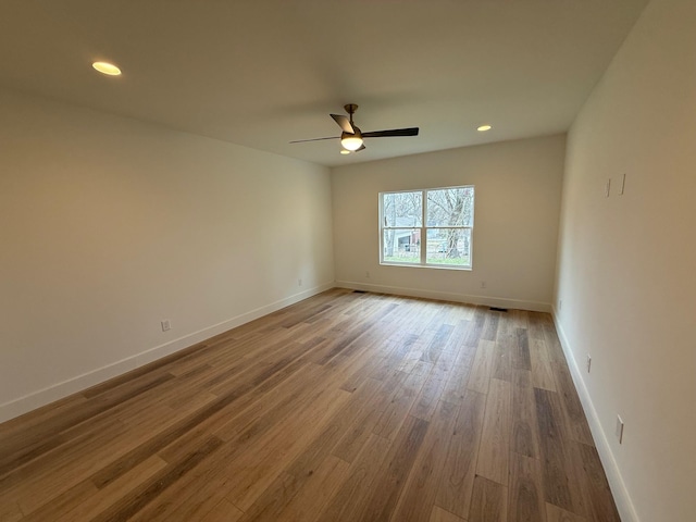 spare room featuring recessed lighting, baseboards, wood finished floors, and a ceiling fan