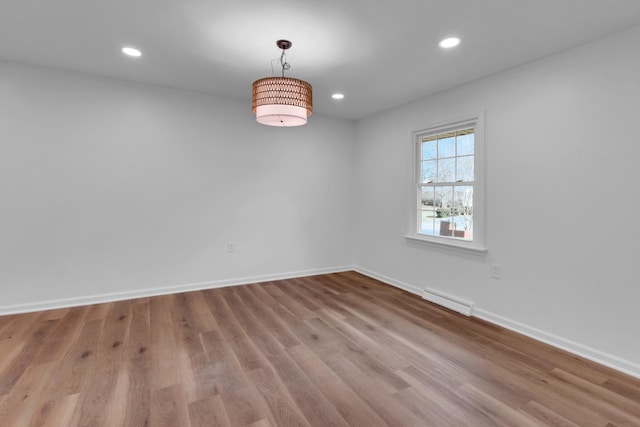 empty room with recessed lighting, wood finished floors, visible vents, and baseboards