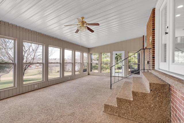 unfurnished sunroom with lofted ceiling and a ceiling fan