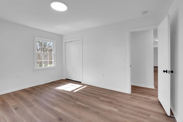 empty room with visible vents, wood finished floors, and baseboards