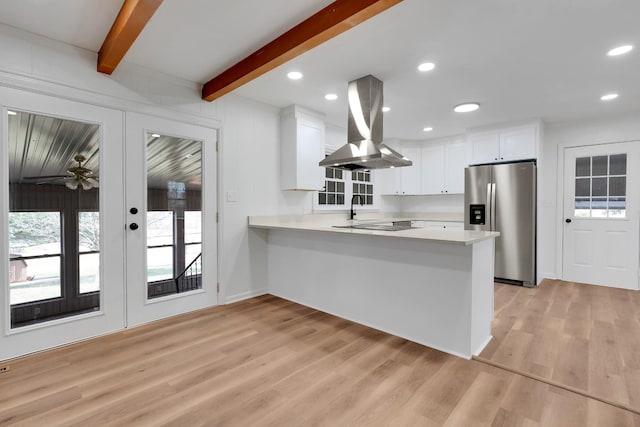 kitchen with light countertops, beamed ceiling, island exhaust hood, and stainless steel refrigerator with ice dispenser