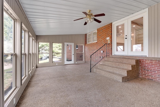 unfurnished sunroom featuring a ceiling fan