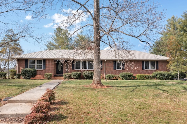 single story home featuring a front yard, brick siding, and metal roof