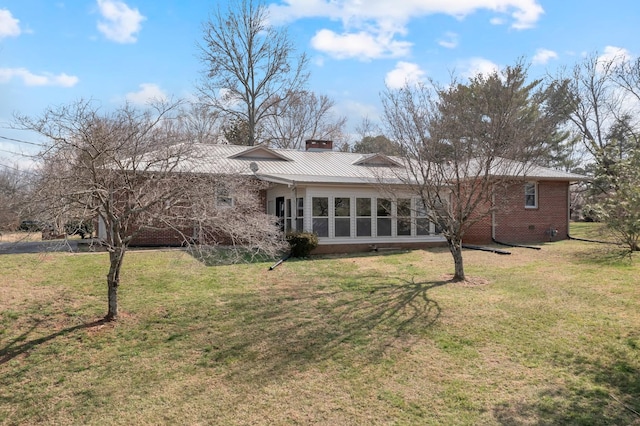 rear view of house with crawl space, a chimney, a yard, and brick siding